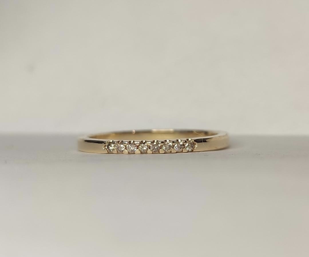 Ring Ellinor i 18K guld med champagnefärgade diamanter liggande mot underlag