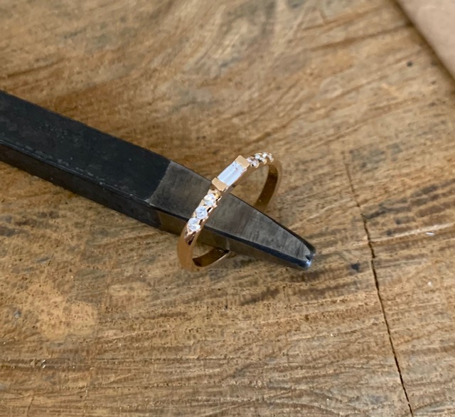 Ring Michelle stående mot en smyckesstämpel i metall