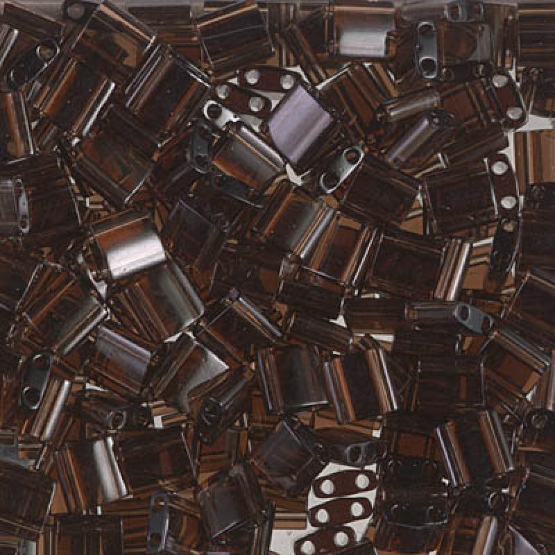 Miyuki Tila glaspärlor i färgen Transparent Brown TL0135, rektangulära 5x2,5 mm pärlor med två hål, visade i närbild.