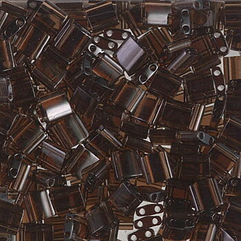 Miyuki Tila glaspärlor i färgen Transparent Brown TL0135, rektangulära 5x2,5 mm pärlor med två hål, visade i närbild.