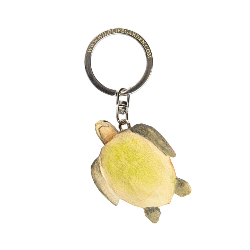 Porte-clés Tortue de mer vu de dessous avec une tortue sculptée à la main sur fond blanc.