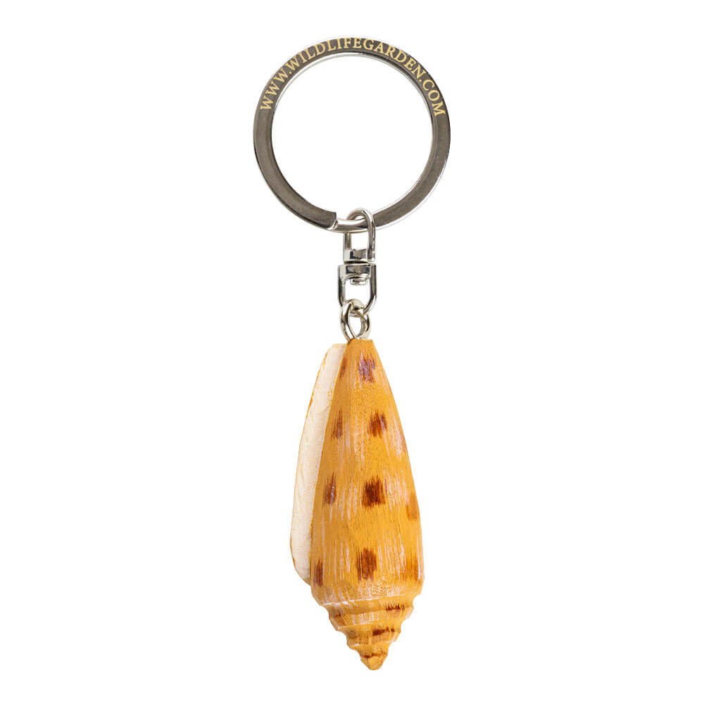 Porte-clés Pétoncle vu de dessous avec une coquille sculptée à la main sur fond blanc.