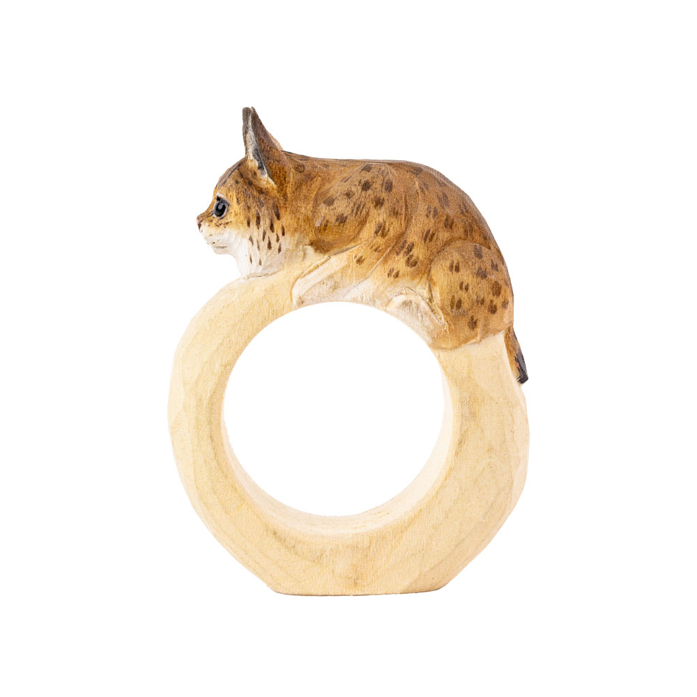 Rond de serviette – Lynx Mini en vue latérale, avec le lynx posé sur l’anneau en bois lisse.
