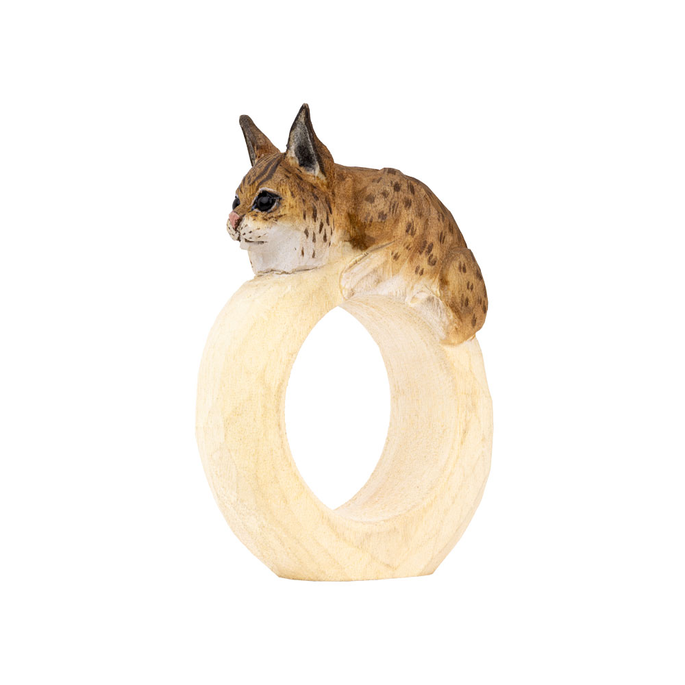 Rond de serviette – Lynx Mini vu en angle, avec le lynx posé sur l’anneau en bois arrondi.