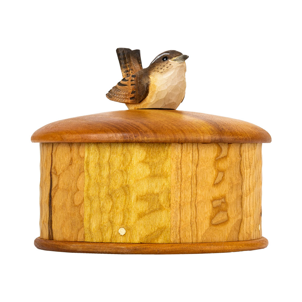 Coffret Troglodyte Mignon vu en angle, mettant en valeur le veinage du bois de cerisier et le troglodyte sculpté.