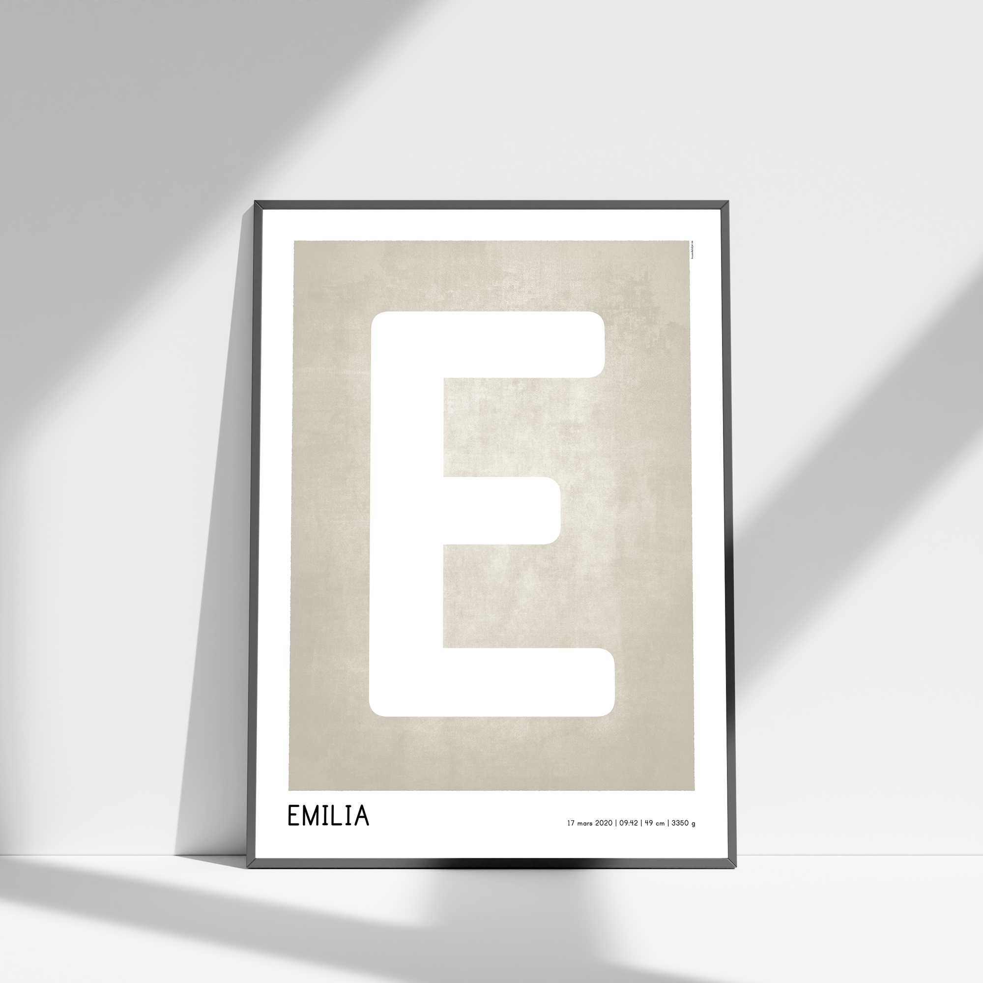 Poster med beige, texturerad bakgrund där barnets första bokstav står i fokus. Under initialen lägger jag även in namn, födelsedatum, tid, längd och vikt. Postern finns i storlekarna 30×40 cm och 50×70 cm.