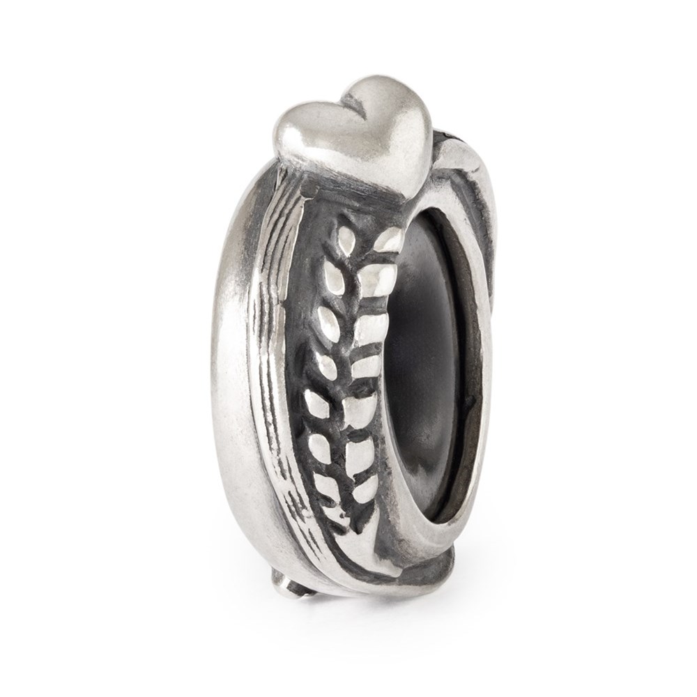 Trollbeads Heart of Harvest Spacer TAGBE-20286 – silver­spacer med hjärta och sädesslingor i detaljrik relief, visad i närbild mot vit bakgrund.