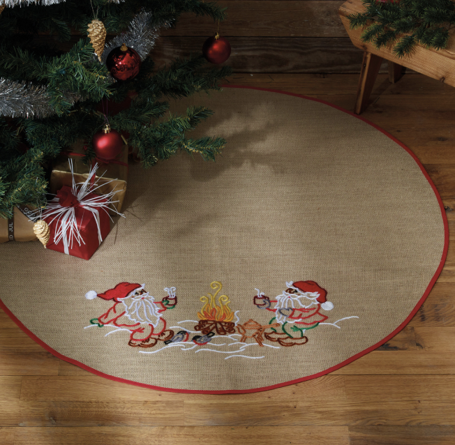 Julgransmatta.  Tomtar dricker något varmt vid elden.