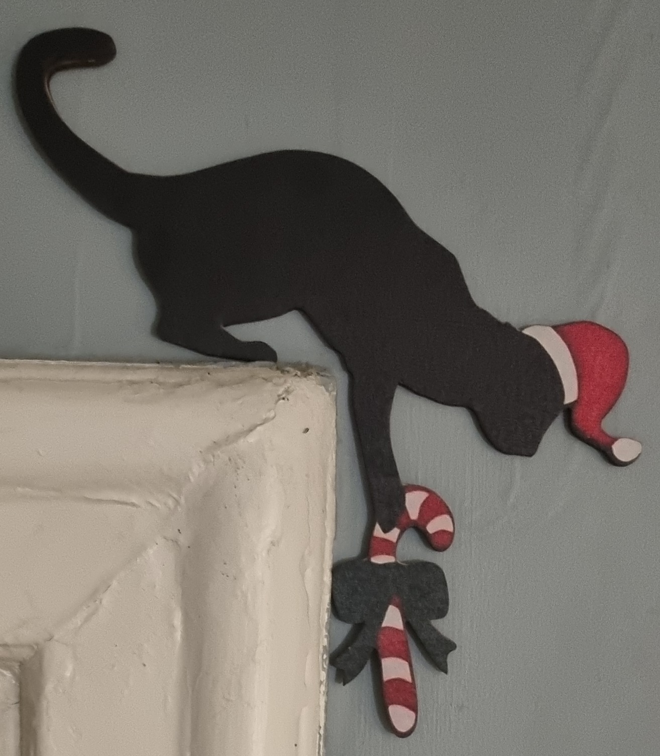 Skylt i träfaner att sätta ovanför dörrfodret "Julkatt med polkagris" - 2