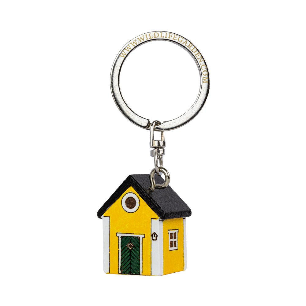 Porte-clés Maison Jaune vu de trois quarts sur fond clair.