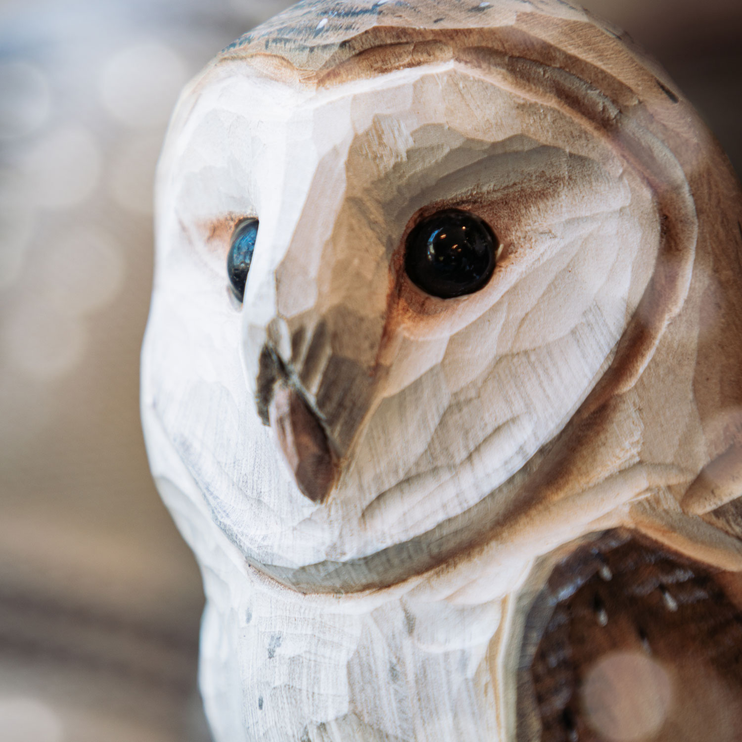 Chouette effraie sculptée à la main en bois avec fleurs, bûches et petite souris à l’arrière-plan.