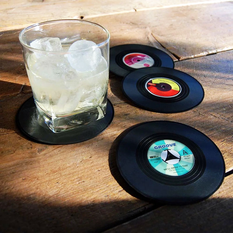 Glasunderlägg vinylskivor med drinkglas på ett bord