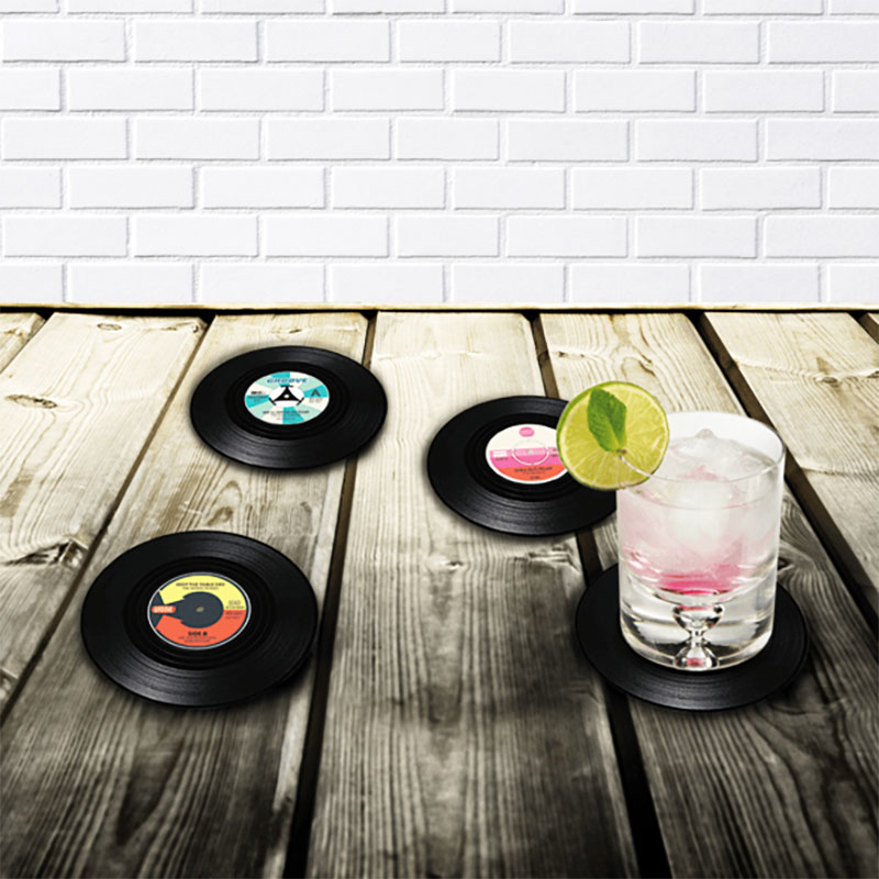 Glasunderlägg liknandes vinylskivor och en drink på ett bord