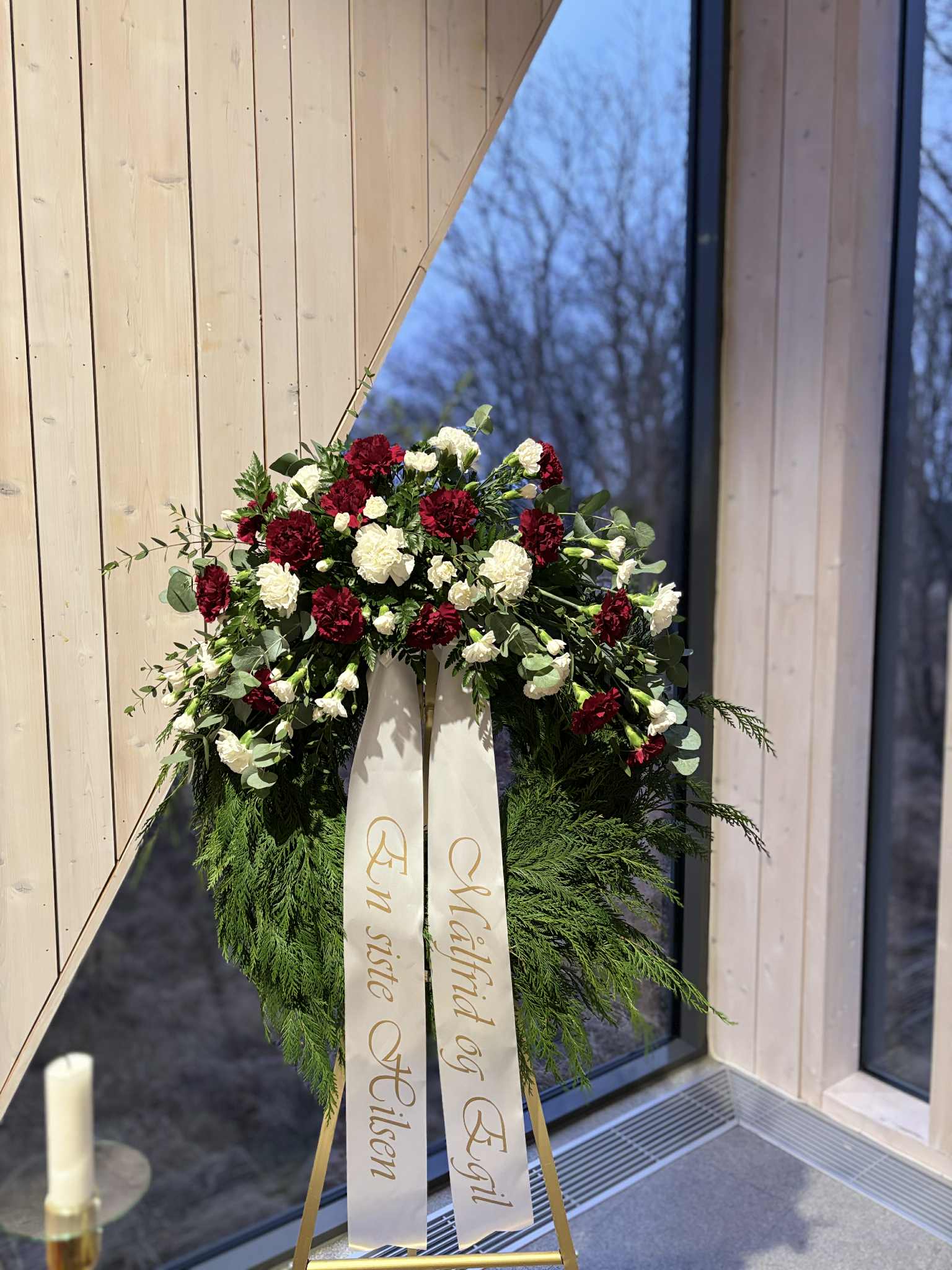 Begravnings krans med cypress och nejlikor