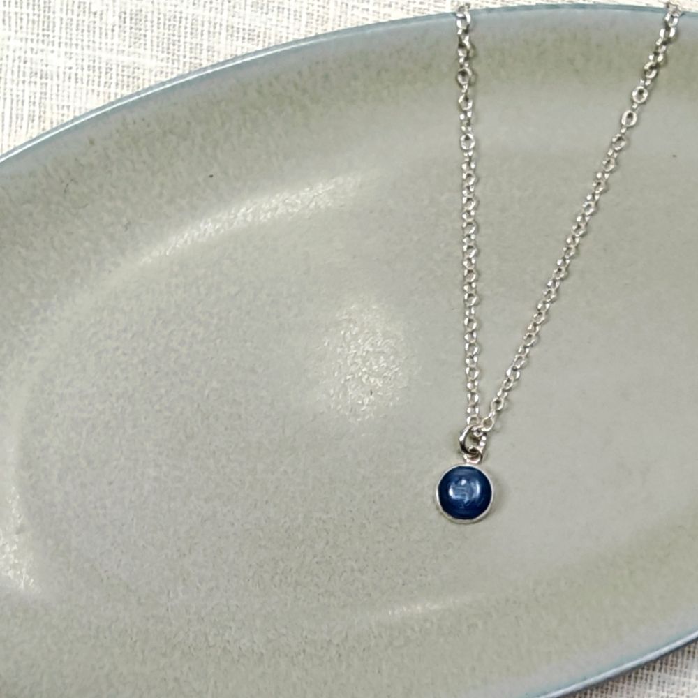 IAMLUND Dew halsband kyanit, blå, runt hänge 8 mm på silverkedja 42,5–45 cm, visas i närbild på ljus bakgrund.