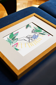 DMC broderikit med läsande kvinna i hängmatta. Broderiet är inramat.