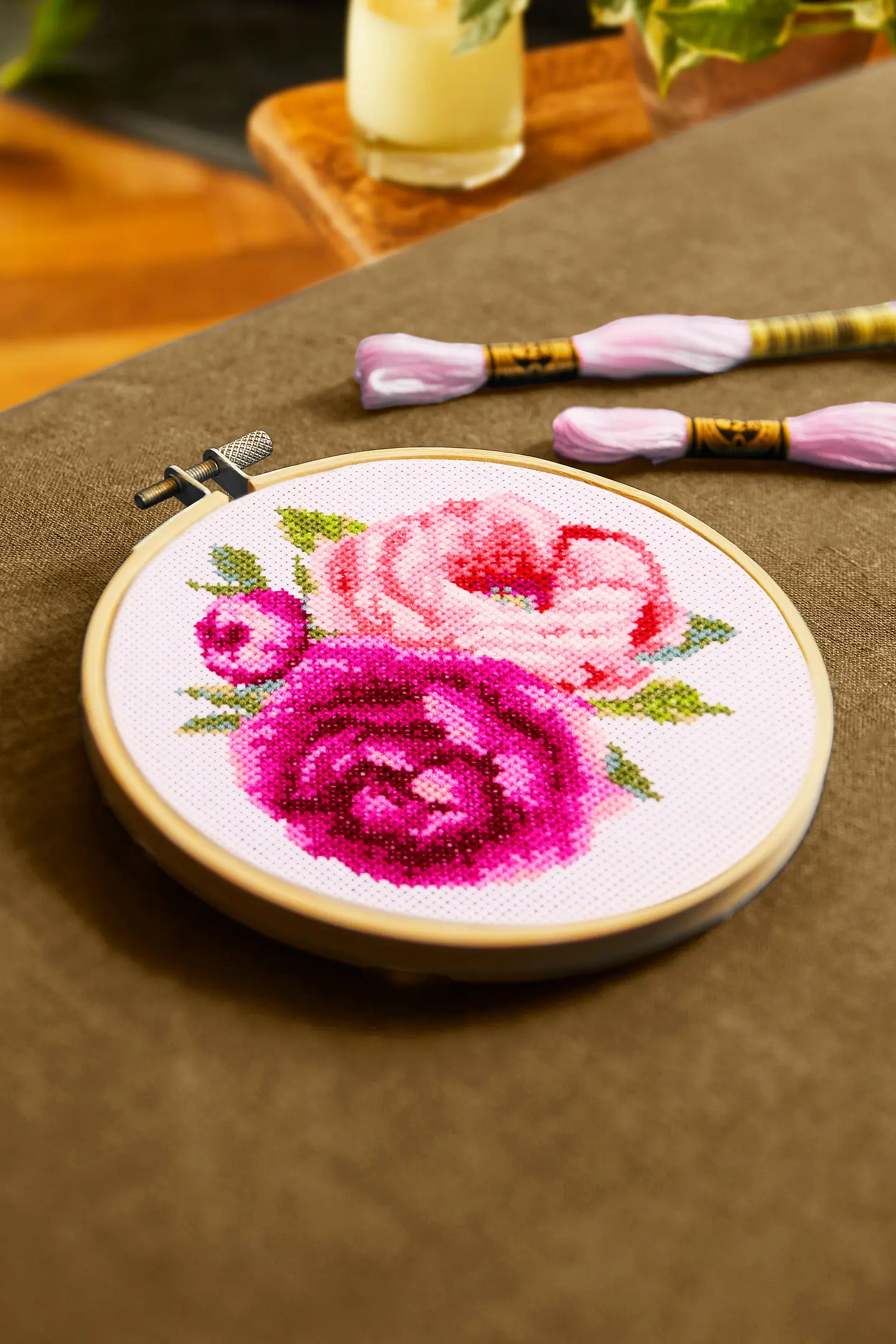 DMC 1895 broderikit rosa pioner i närbild i broderiring liggande på bord.