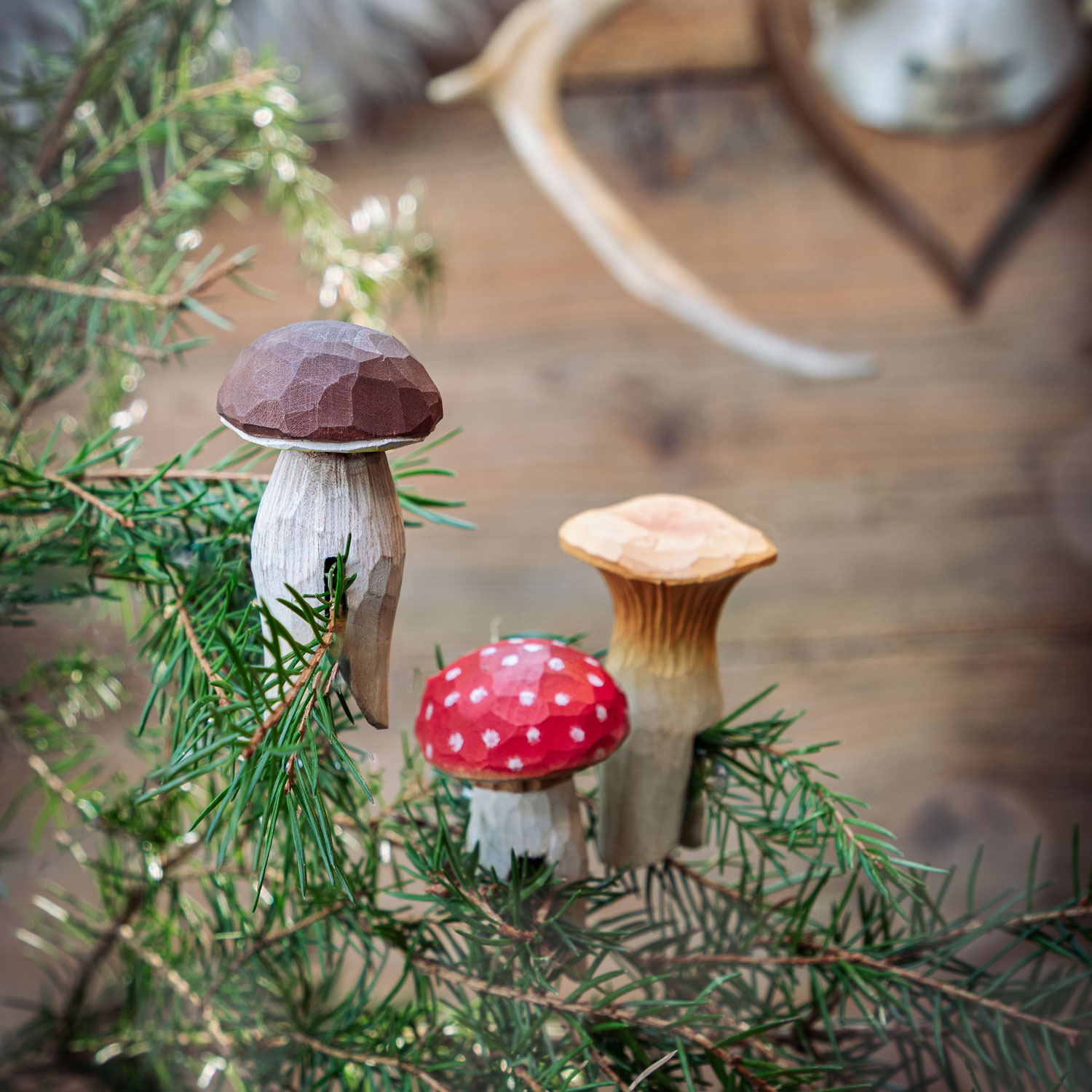 Forest Décor – Mushrooms with fly agaric, chanterelle and penny bun placed on spruce branches in a winter setting.