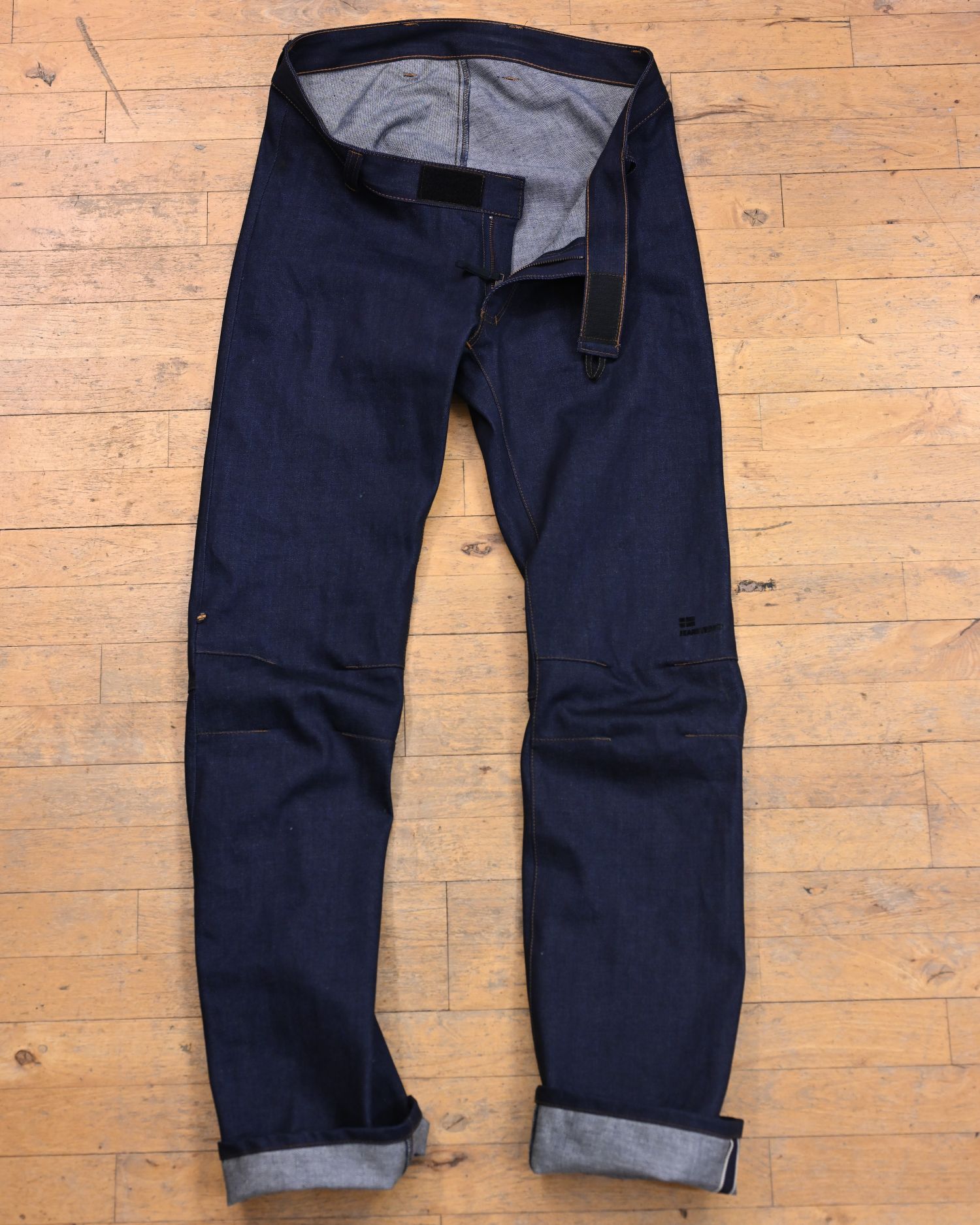 Dark blue wheelchair-accessible jeans lying on the floor, 100% organic cotton