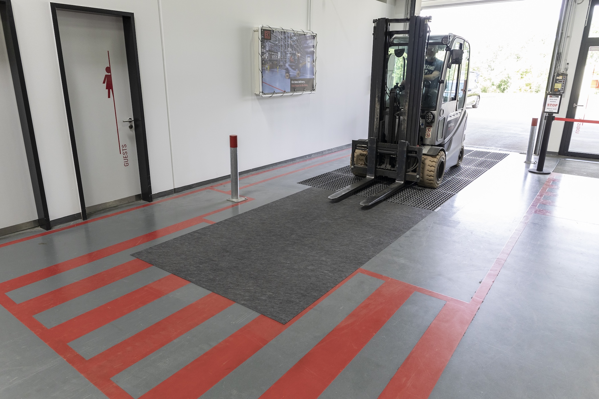 Gaffeltruck i passage kör över dryzone basic för att torka hjulen.