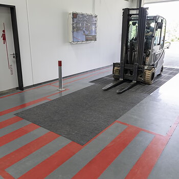 Gaffeltruck i passage kör över dryzone basic för att torka hjulen.