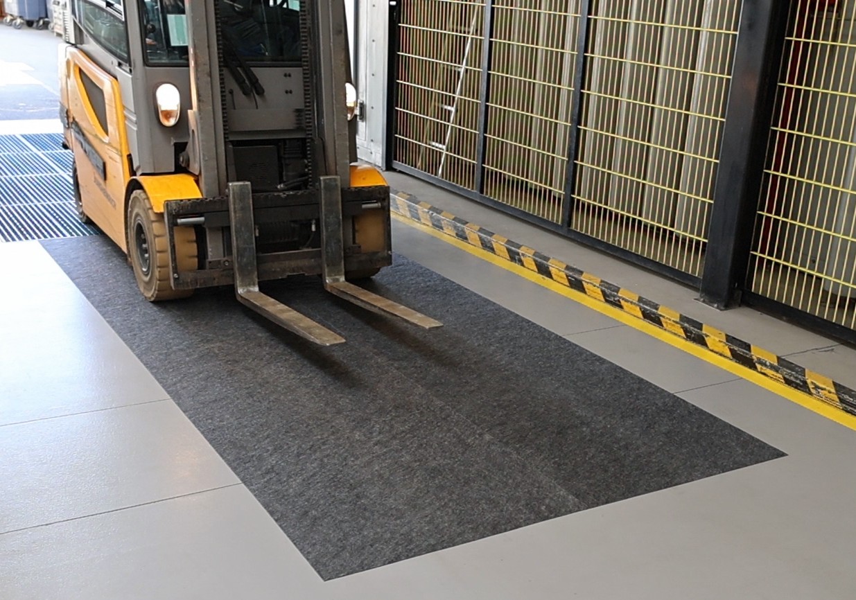 Gaffeltruck på lager kör över dryzone basic för att torka hjulen.