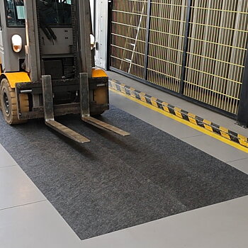 Gaffeltruck på lager kör över dryzone basic för att torka hjulen.