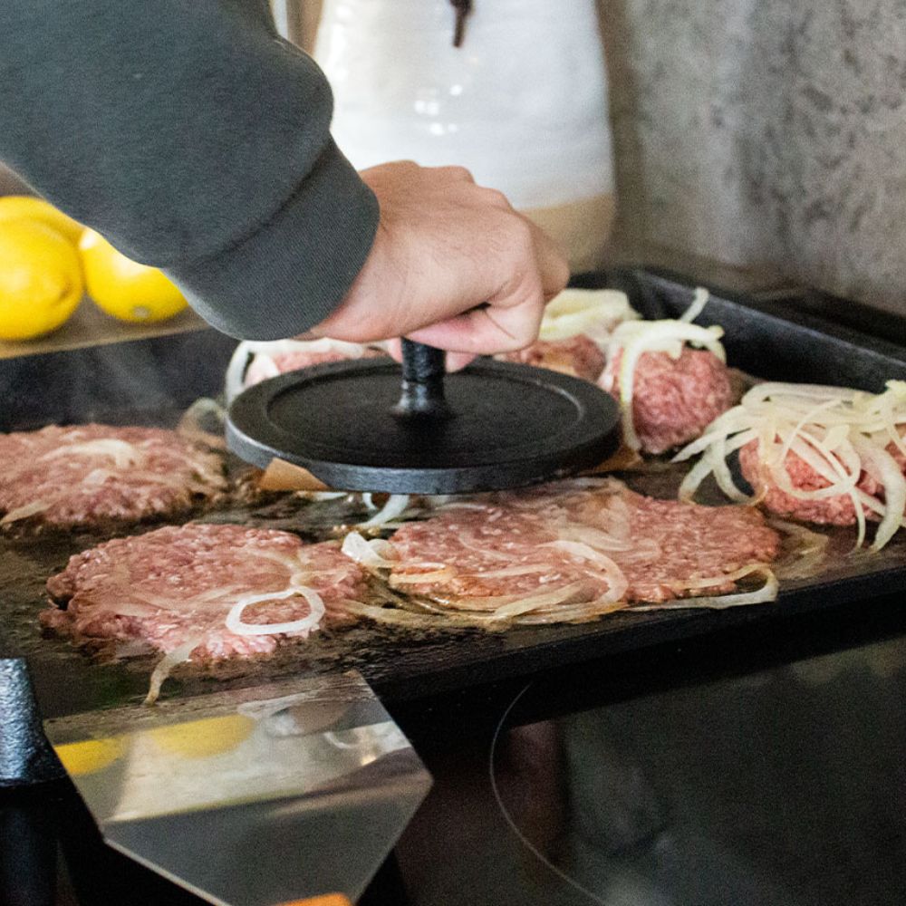 Smasher-hamburgerpressen presses ned på Norrjerns stegebord i støbejern.