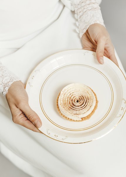 Dessert serverad på papperstallrik i vitt och guld