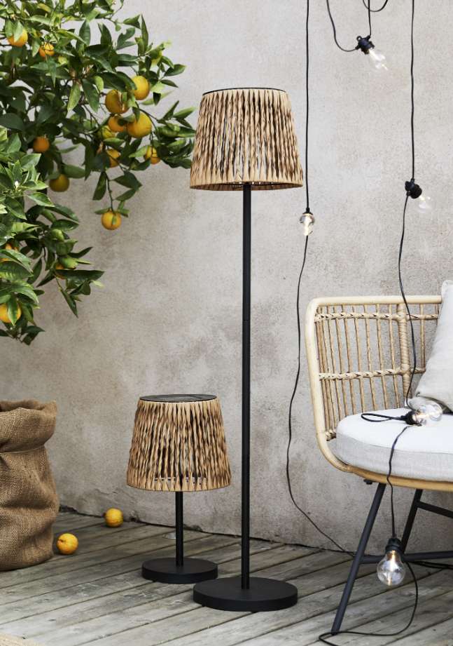 Flätverk solar rattan floor lamp and matching table lamp on a wooden deck by a lemon tree and rattan chair