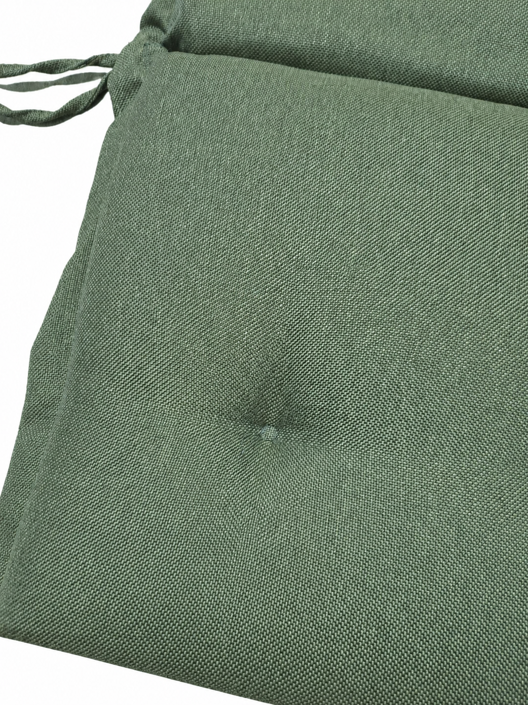 Detalj av grön stolsdyna med pikering och hög rygg