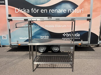 Rostfri bänk med överhylla på ståndare.