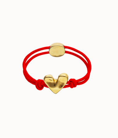 Armband av rött elastiskt snöre med ett hjärta pläterat med 18-karats guld.