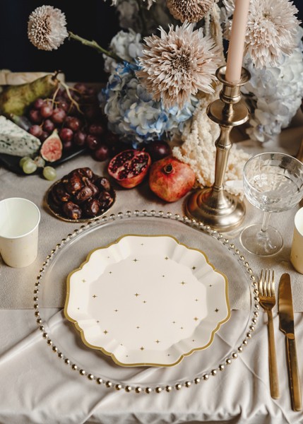 Beige papptallrikar med guldstjärnor i elegant festdukning