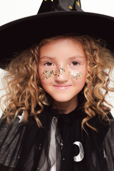 Guldglitter i ansiktet på barn med Halloween utklädnad