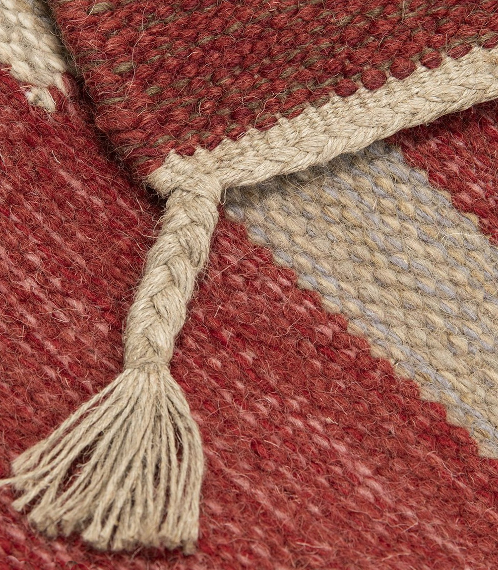 Detaljbild på Röllakan Lindö Röd från Axeco flätad fransfläta i lin