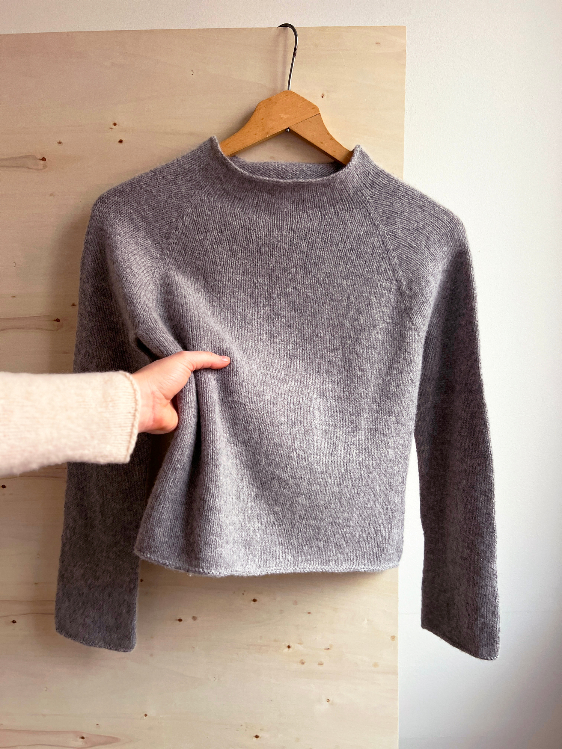 Lun Lenibluse – grå stickad tröja i Lun Merino på galge