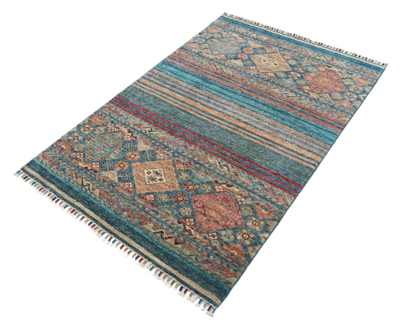 Samarkand Blå 101x154 cm fotograferad snett uppifrån, med dekorativa medaljonger, randigt mittparti och färgade fransar.