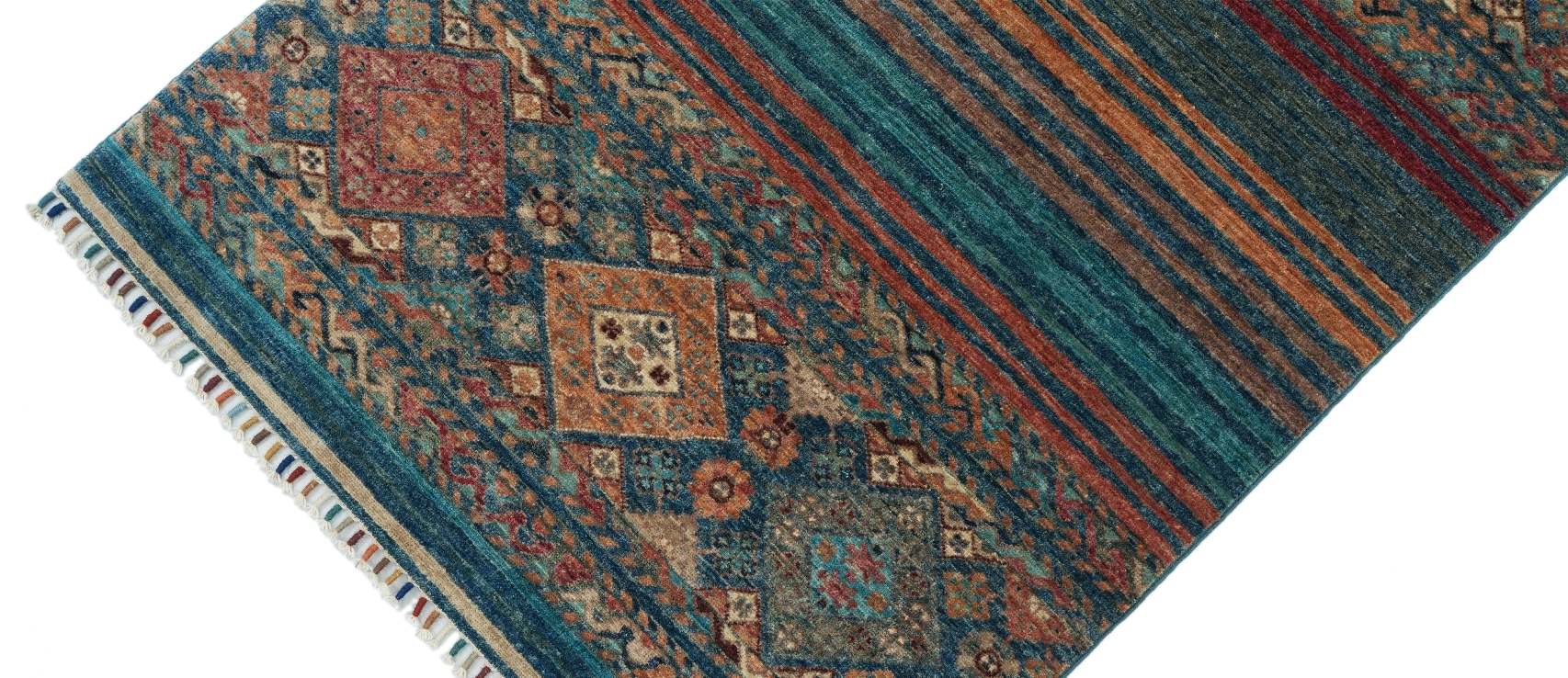 Närbild av Samarkand Blå 101x154 cm som visar ullmattans geometriska mönster, växtfärgade garn och dekorativa fransar.