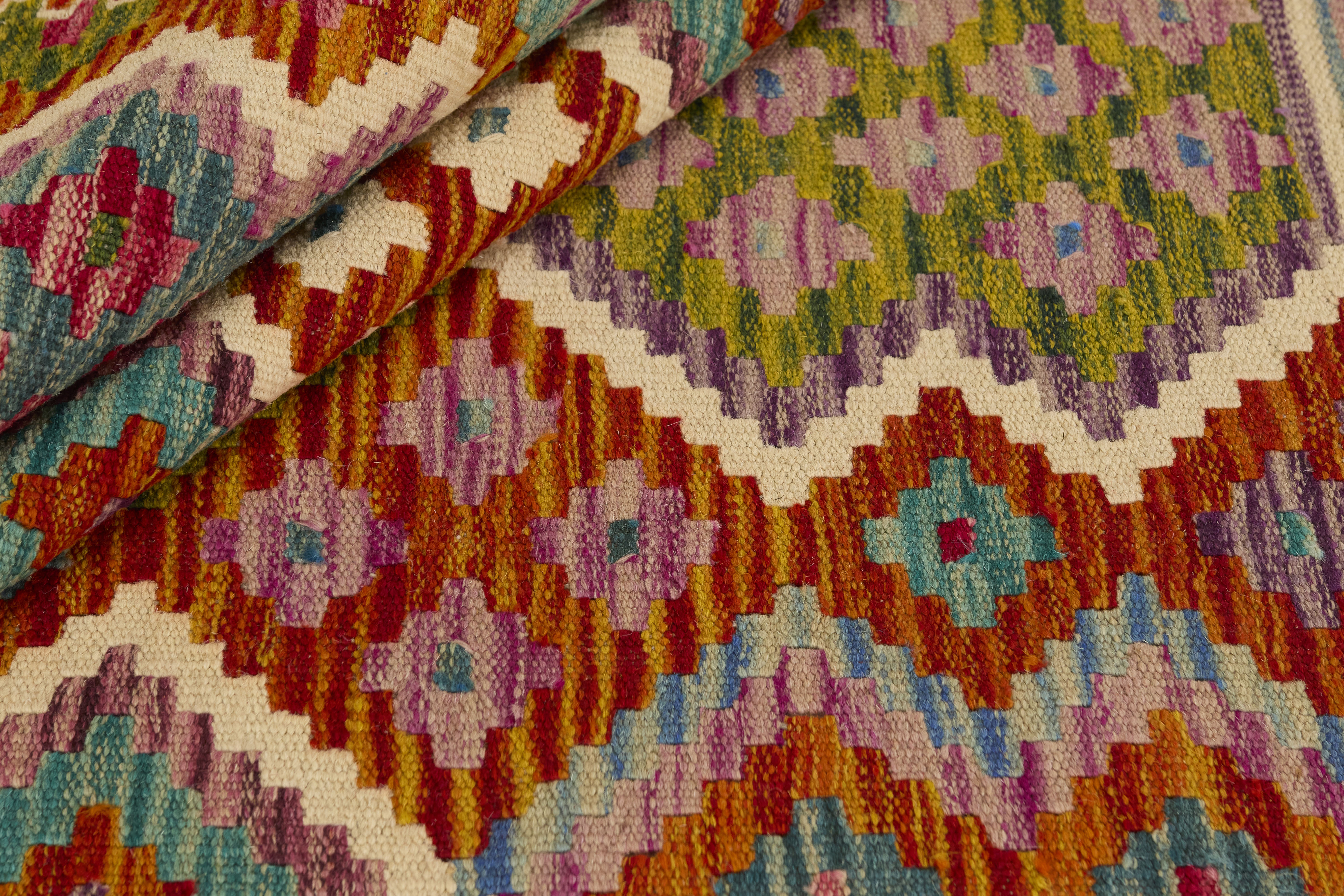 Närbild av Kelim 201x308 cm som visar dess täta struktur och mönster i turkos, lila och rött, grönt och vitt.