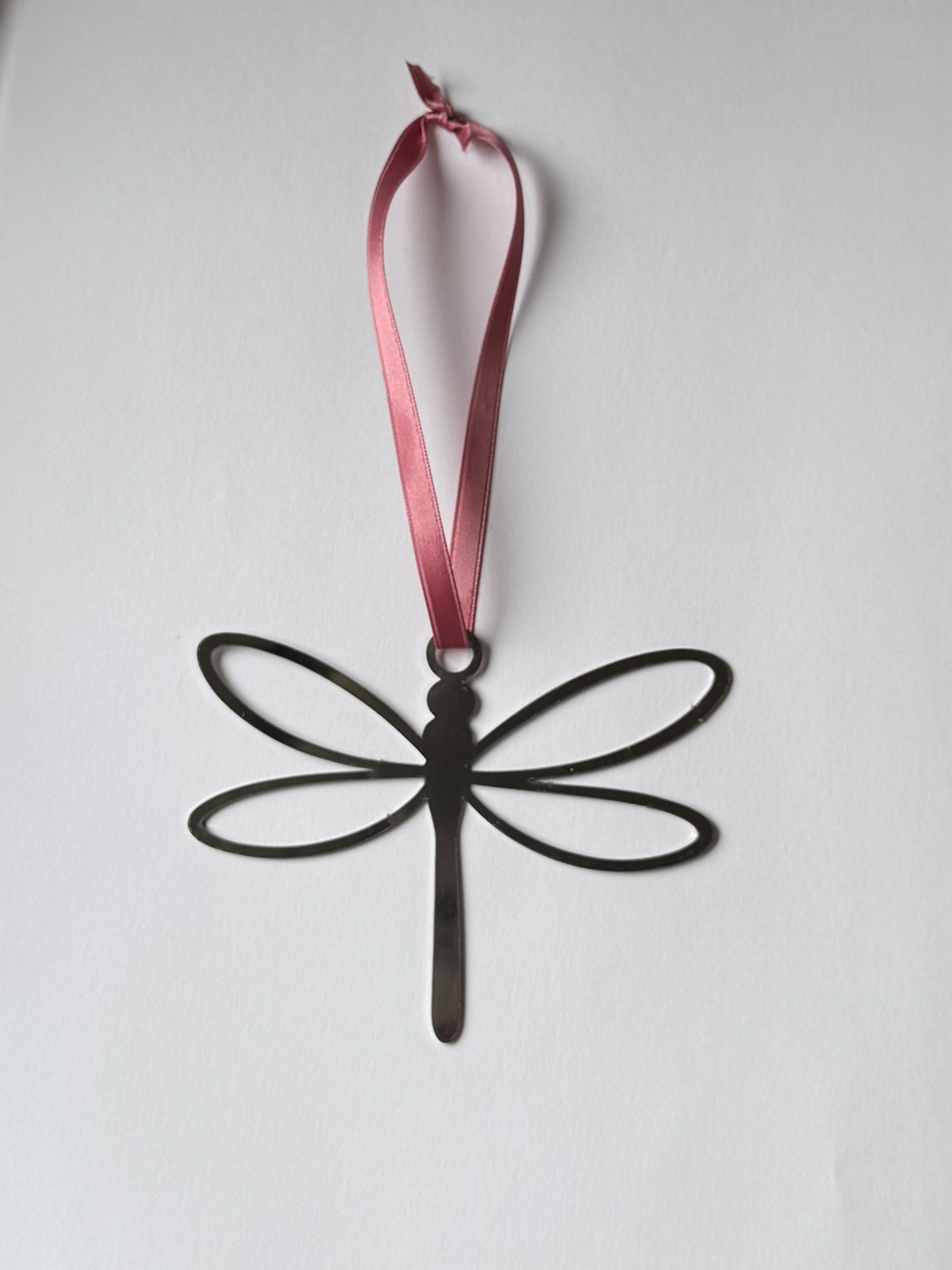 Liten stålslända med rosa satinband