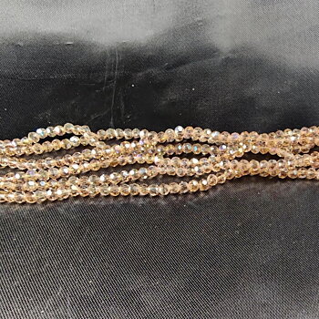 Facetterade glaskristallpärlor i rondellform, champagne AB, ca 3 mm, uppträdda på hel sträng.