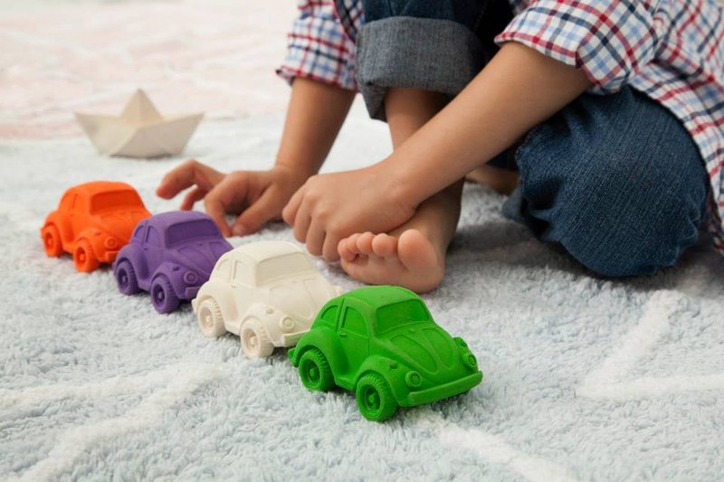 Lapset leikkimässä luonnonkumisilla leikkiautoilla