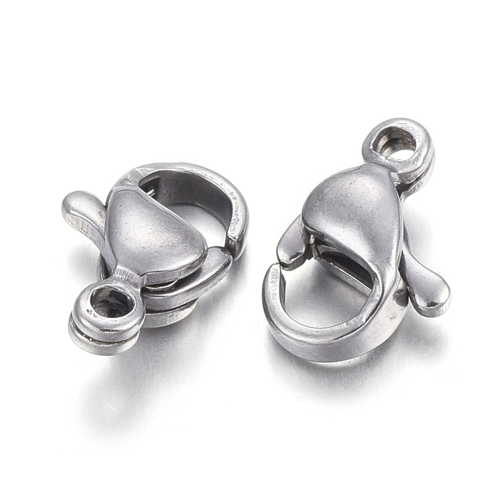 Lobsterlås i rostfritt stål, 9x6 mm med ca 1 mm hål, 10 st förpackning. Närbild som visar två små smyckeslås bredvid varandra.