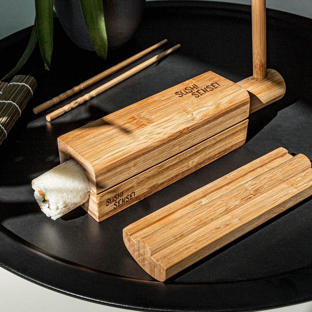 Pressar ut maki-rulle ur sushiform