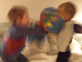To børn har en pudekamp med bløde glober