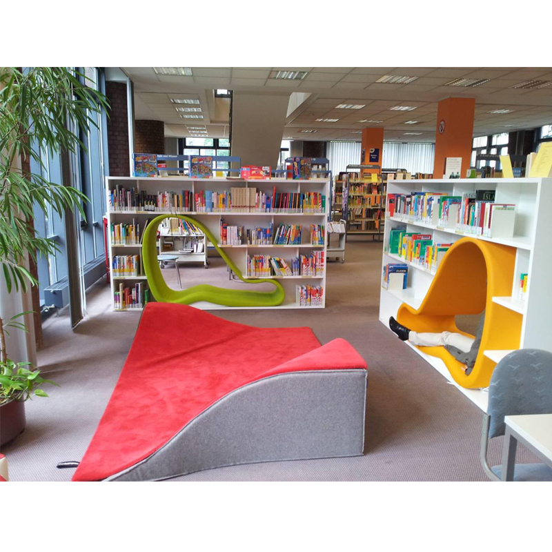 THE CAVE BOOKCASE dubbelsidig bokhylla med integrerad stoppad sittdel och infälld belysning som skapar en privat läskoja för läsning och eftertanke.