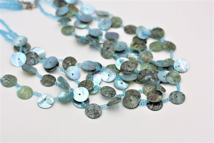 Halsband med pärlemorglänsande snäckskal