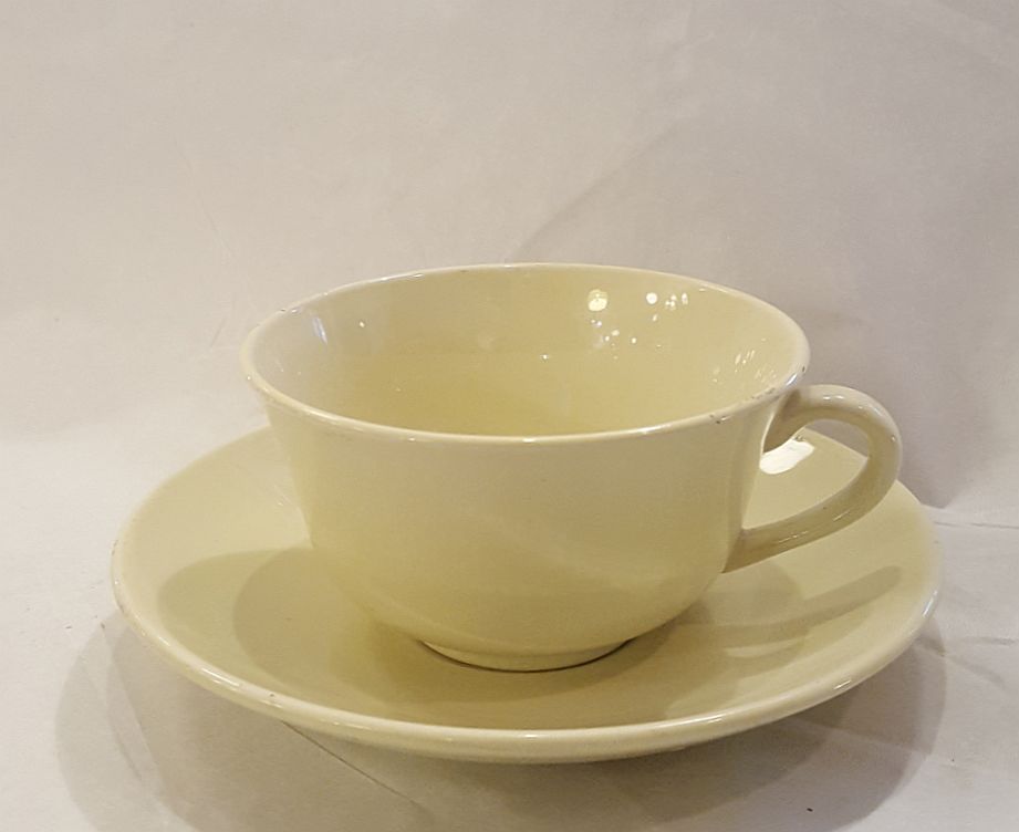 Gul kaffekopp och fat