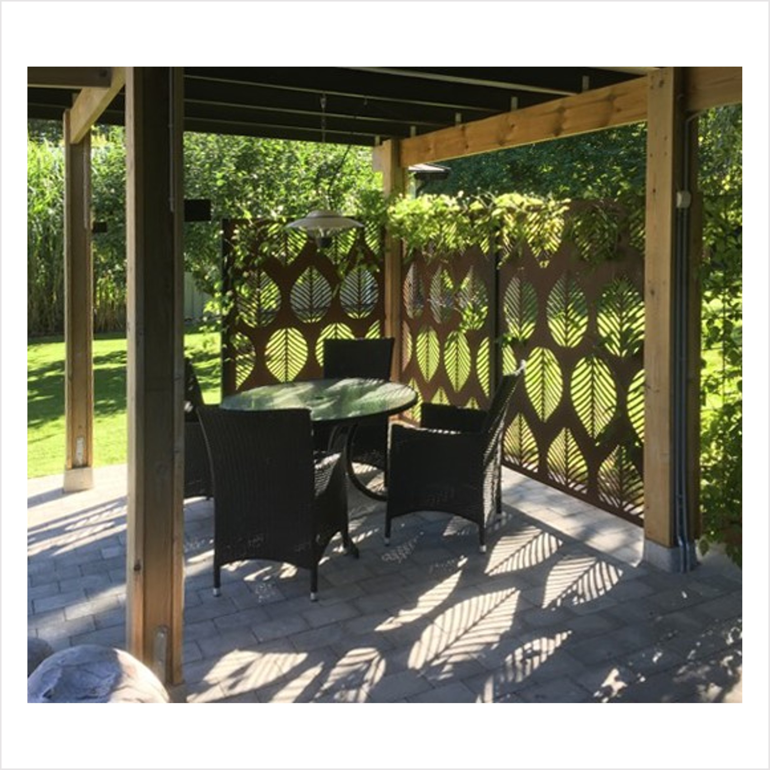 Skärmvägg i pergola, sittgrupp, vackert ljusmönster på marken, gröna växter